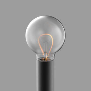 A lit incandescent light bulb with a glowing filament on a gray background.