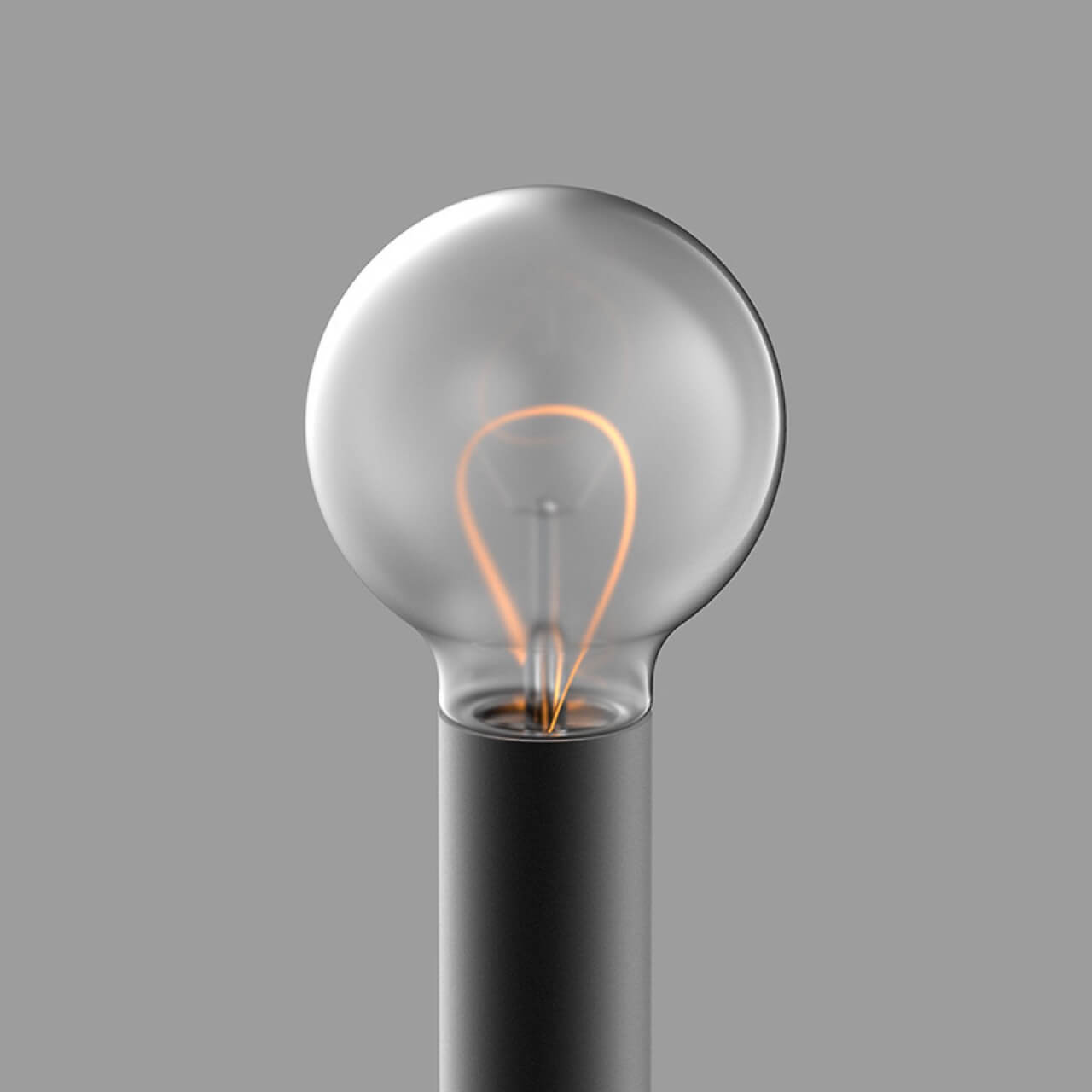 A lit incandescent light bulb with a glowing filament on a gray background.